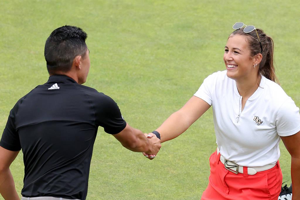 A smiling Jess Baker shakes hands with Collin Morikawa